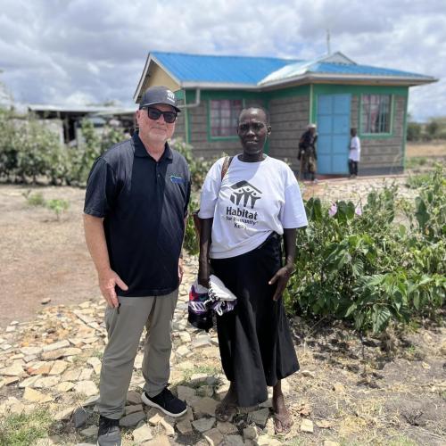 A man and a woman standing in front of a home. 