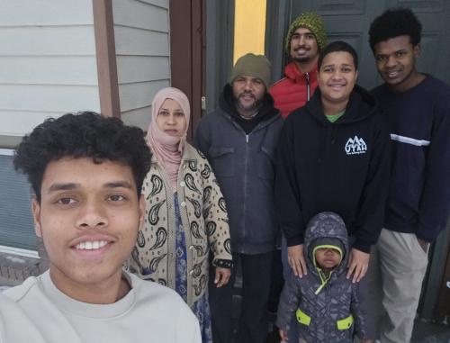 Picture of a family standing in front of their home. 