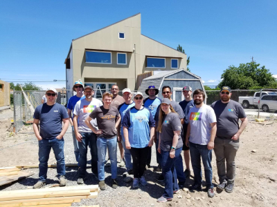 Image of a group of people standing in front of a home.